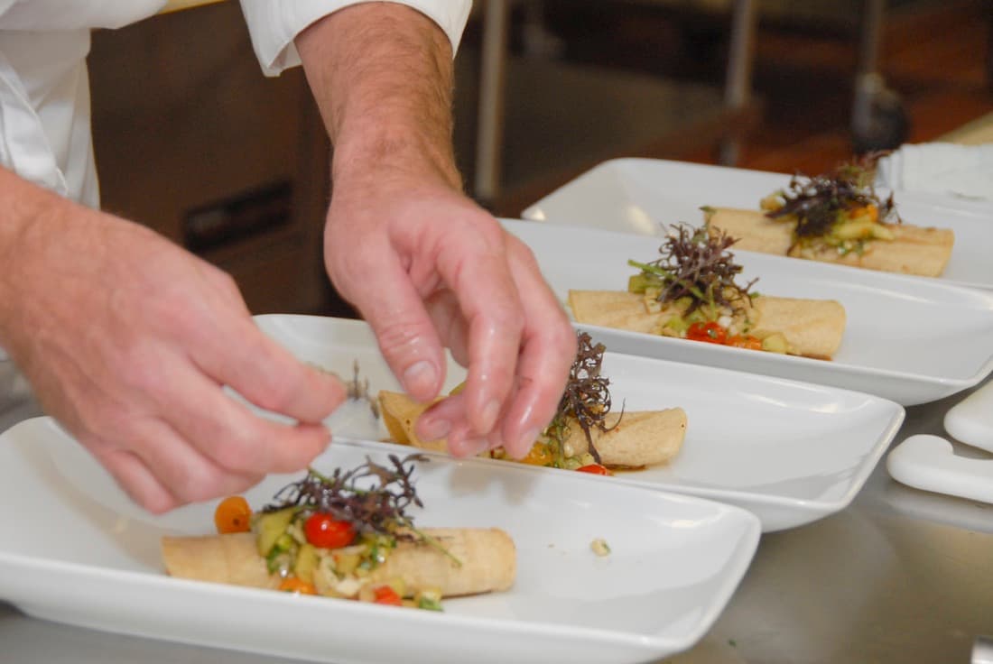 A chef plating a dish on the line