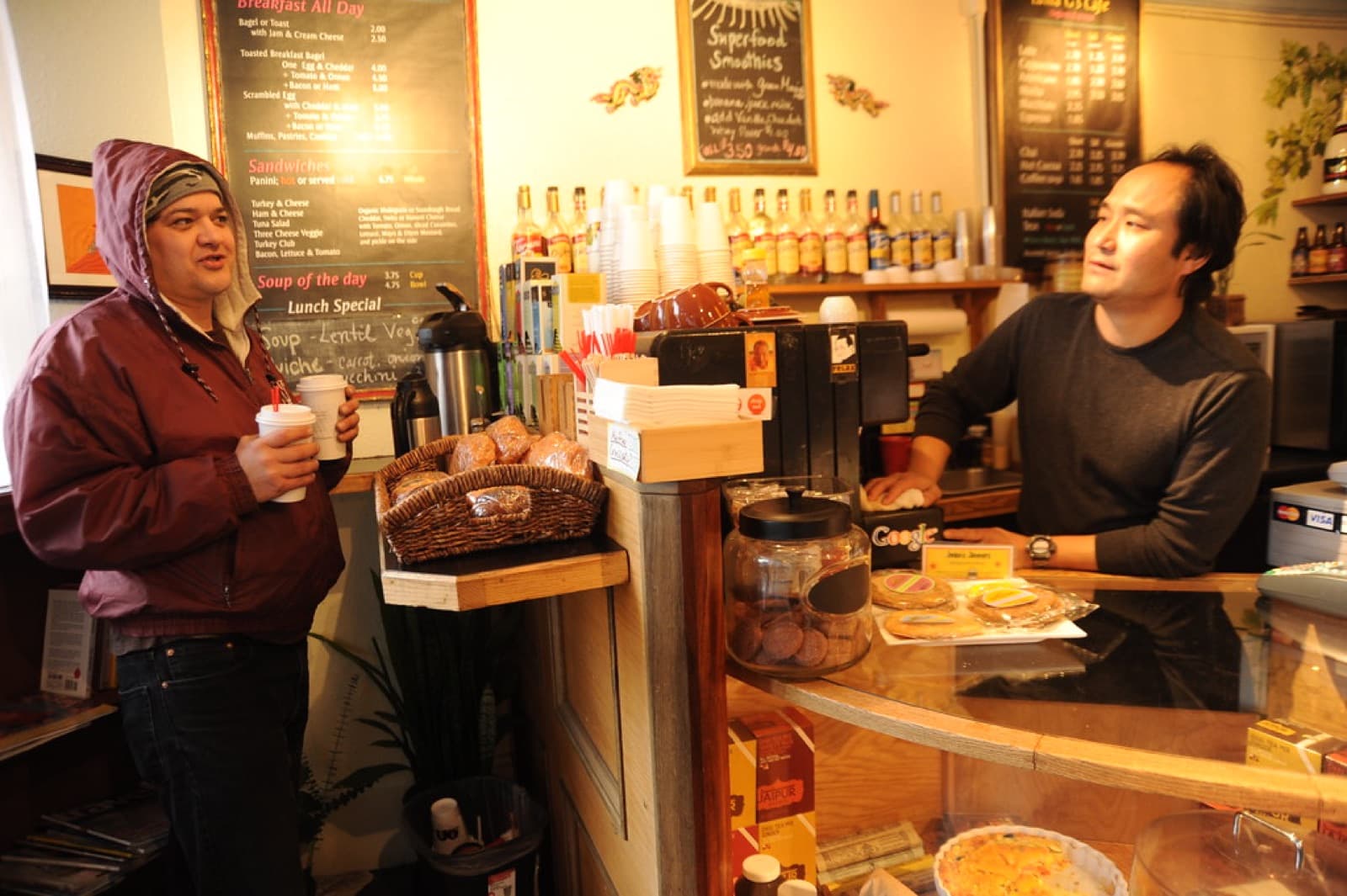 A barista serving a regular customer at the counter