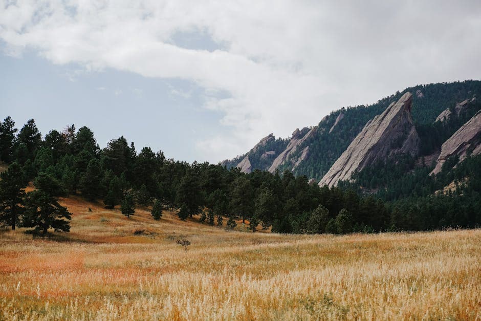Boulder, Colorado at golden hour with the Flatirons sandstone formations rising over downtown and the University of Colorado campus
