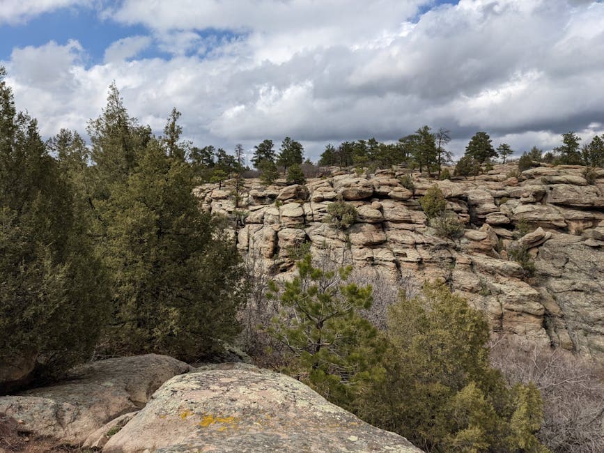 The Castle Rock butte rising over the town with I-25 in the foreground and the Front Range mountains in the distance