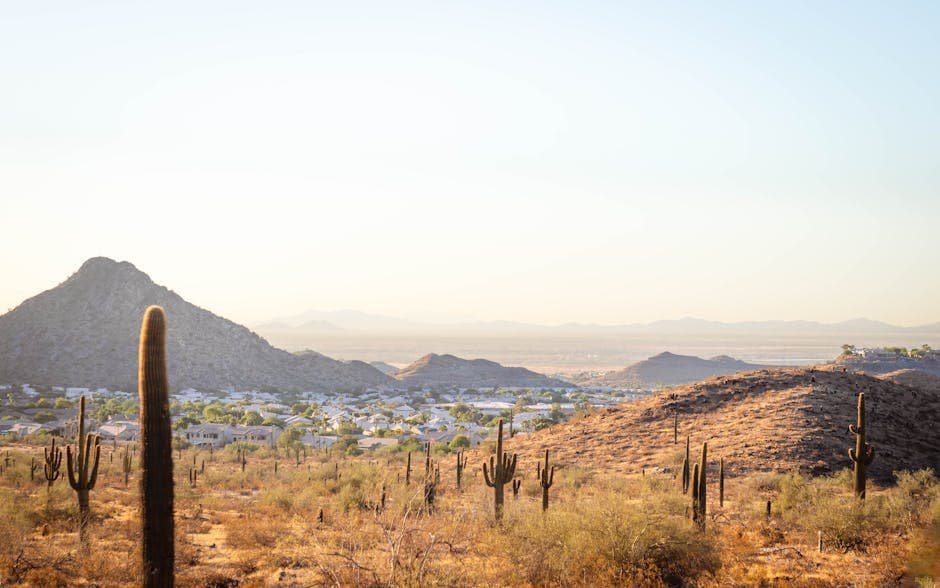 Scottsdale Old Town at golden hour with Camelback Mountain in the distance, saguaro silhouettes against a Sonoran sunset sky, and walkable Mid-Century resort architecture in the foreground