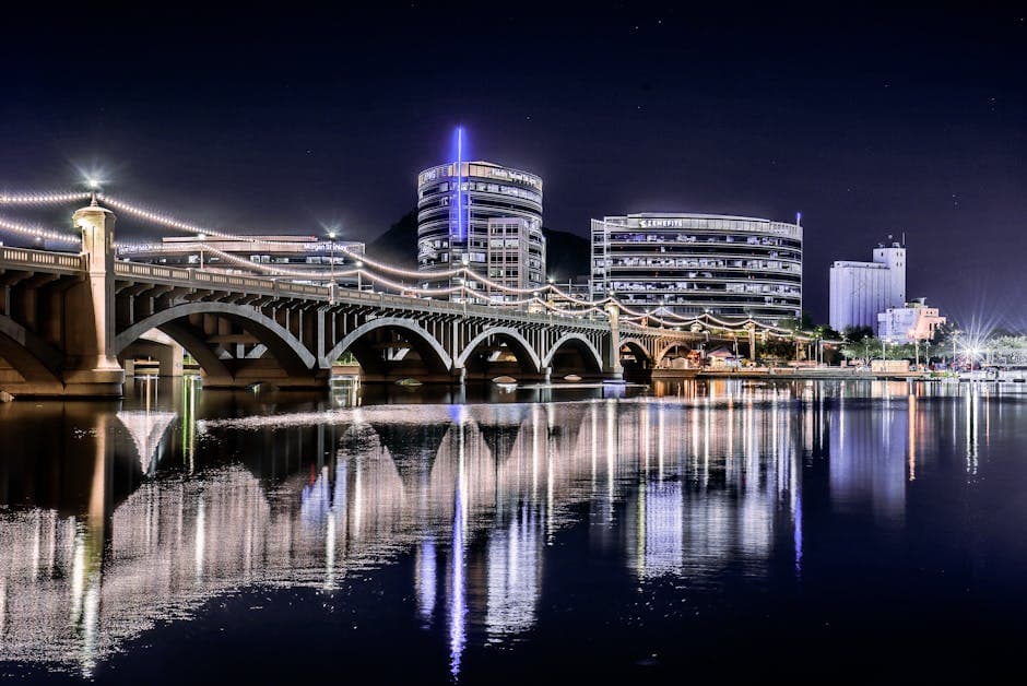 Tempe, Arizona at dusk with A Mountain (Hayden Butte) silhouetted against the sky and Tempe Town Lake reflecting the city lights of the ASU college town